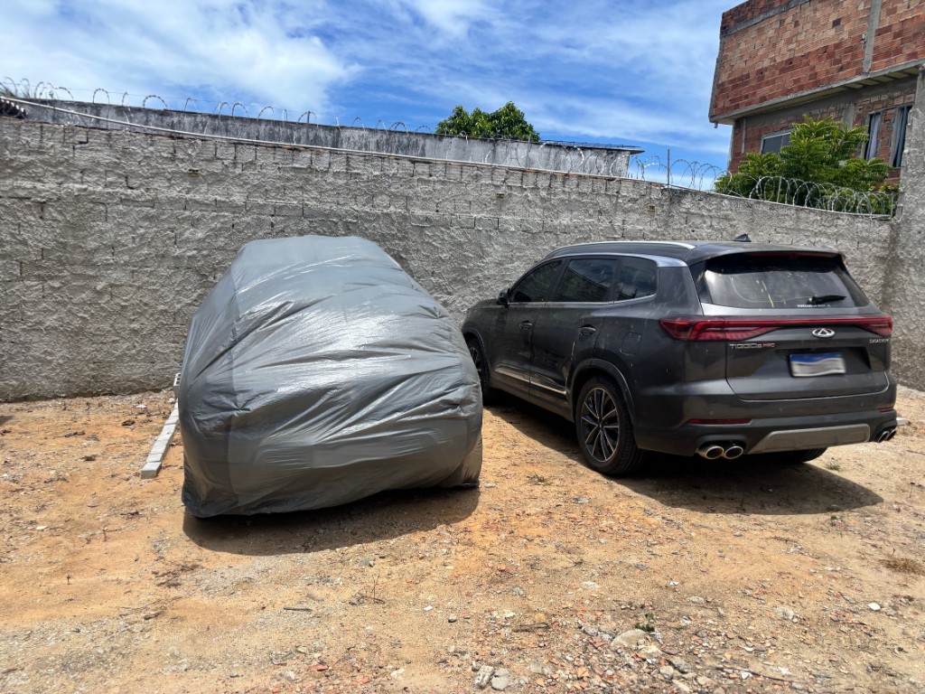 Veículo coberto com capa protetora ao lado de SUV no Park Self Porto Seguro